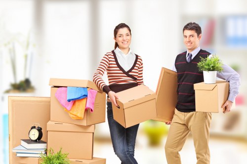 Movers carrying furniture down stairs in an East London student property