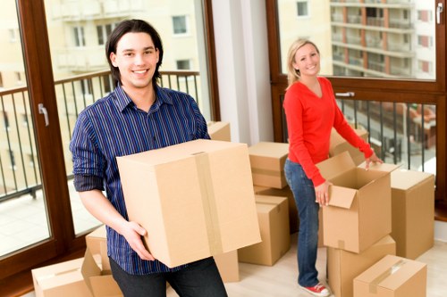 Professional movers carrying household items through a Shoreditch apartment block